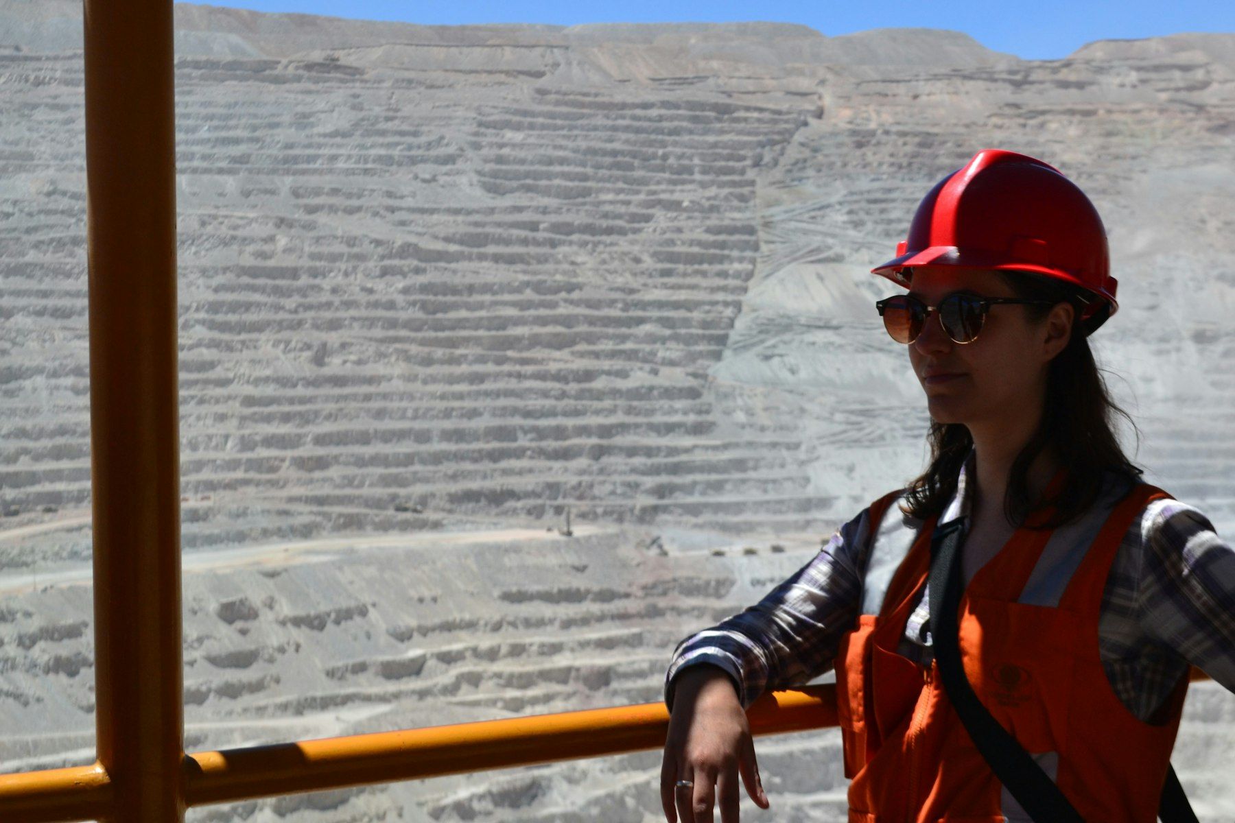 Worker in a hard hat and hi-vis vest at an open-cut mine